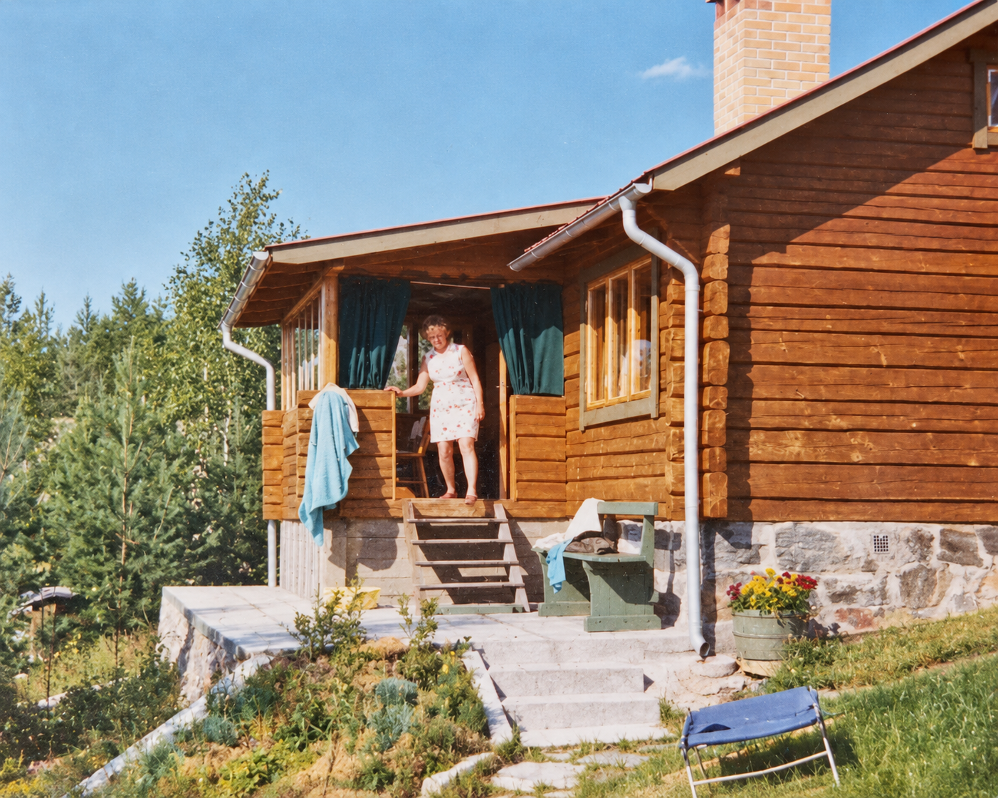 Family photograph of Alexander’s grandmother outside the wooden house in the 1960s